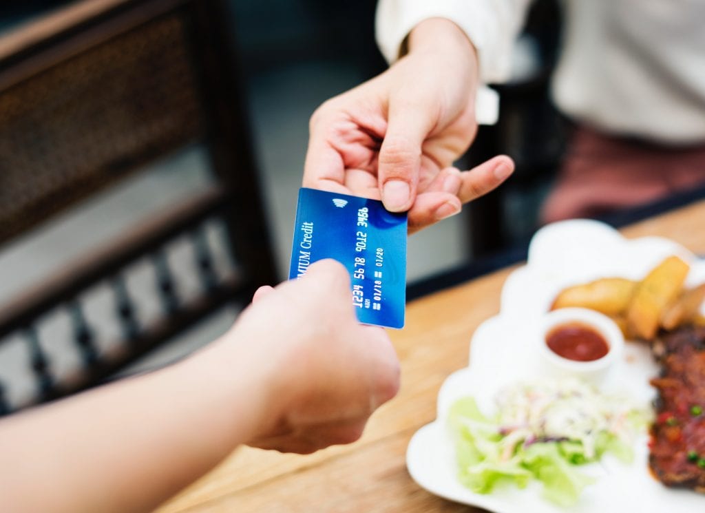 guy purchasing something at a restaurant with a credit card