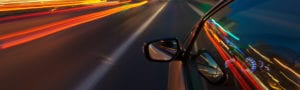 car zooming through street with blurred lights