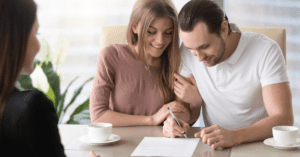 young couple signing an insurance document