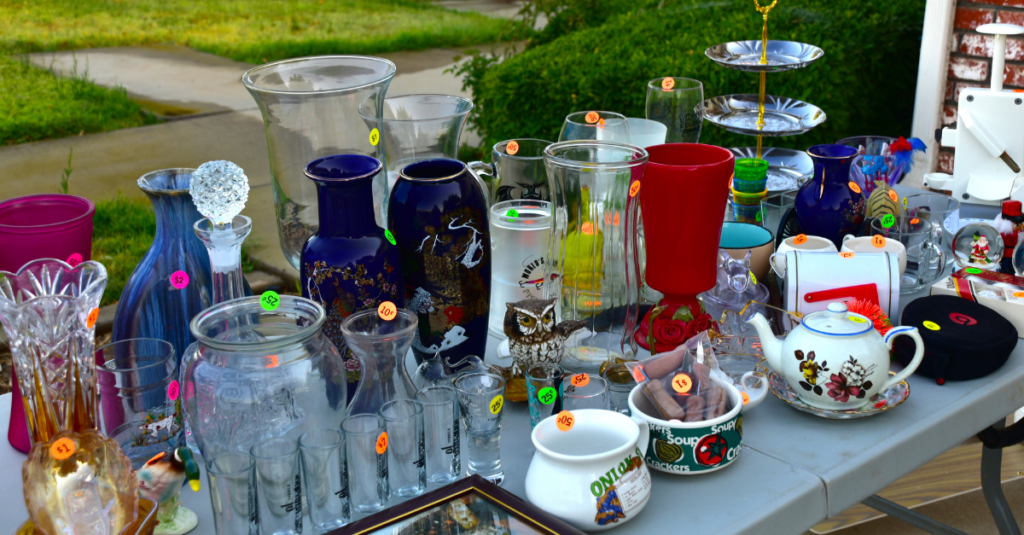 vases and glassware on a table with price stickers at a yard sale