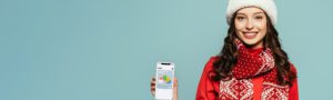 girl in an ugly christmas sweater holding up her phone