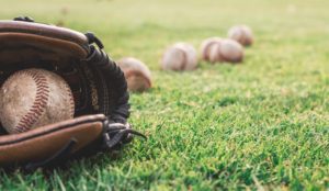 baseball mitt and baseballs in green grass
