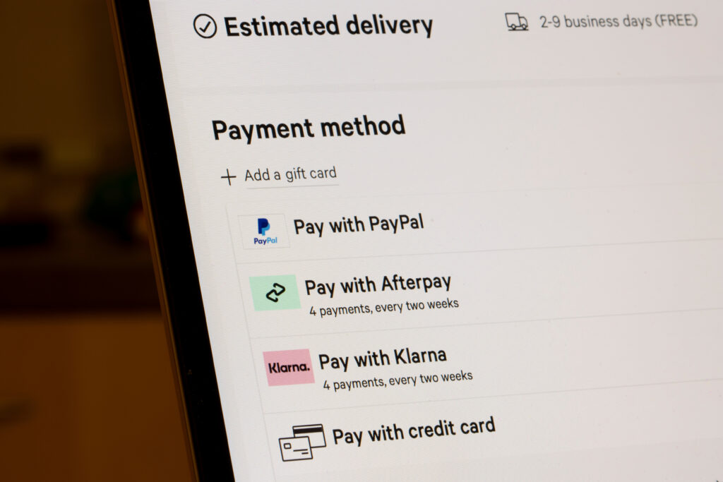 Close-up of a computer screen showing various payment methods: PayPal, Afterpay, Klarna, and credit card options under "Estimated delivery."
