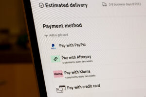 Close-up of a computer screen showing various payment methods: PayPal, Afterpay, Klarna, and credit card options under "Estimated delivery."