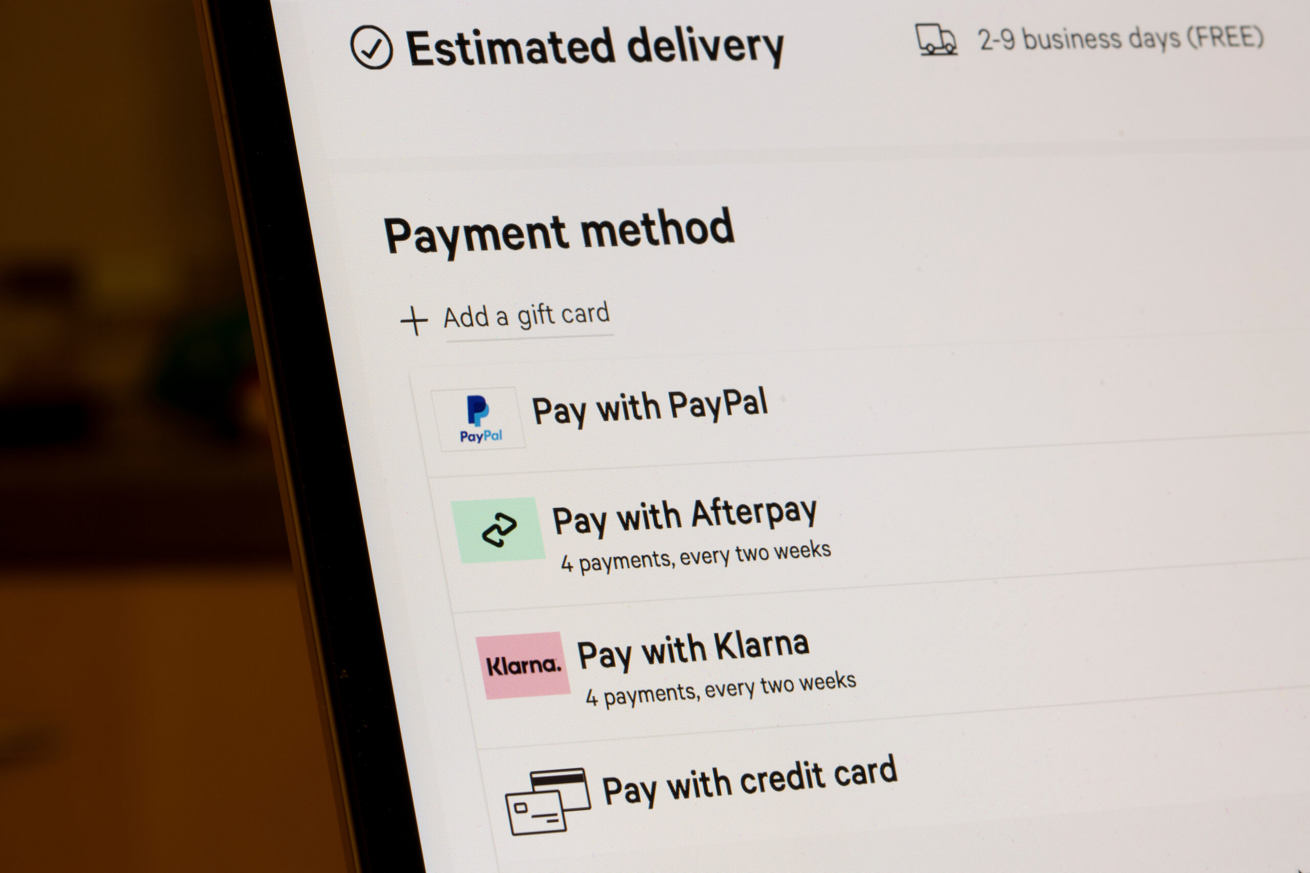 Close-up of a computer screen showing various payment methods: PayPal, Afterpay, Klarna, and credit card options under "Estimated delivery."