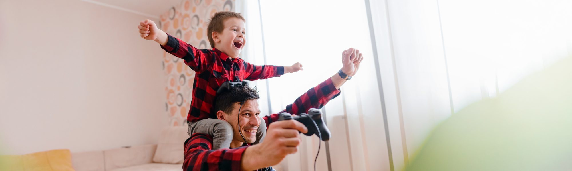 father and child playing video games victorious