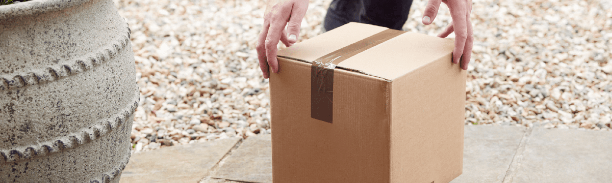 person delivering brown box package on doorstep