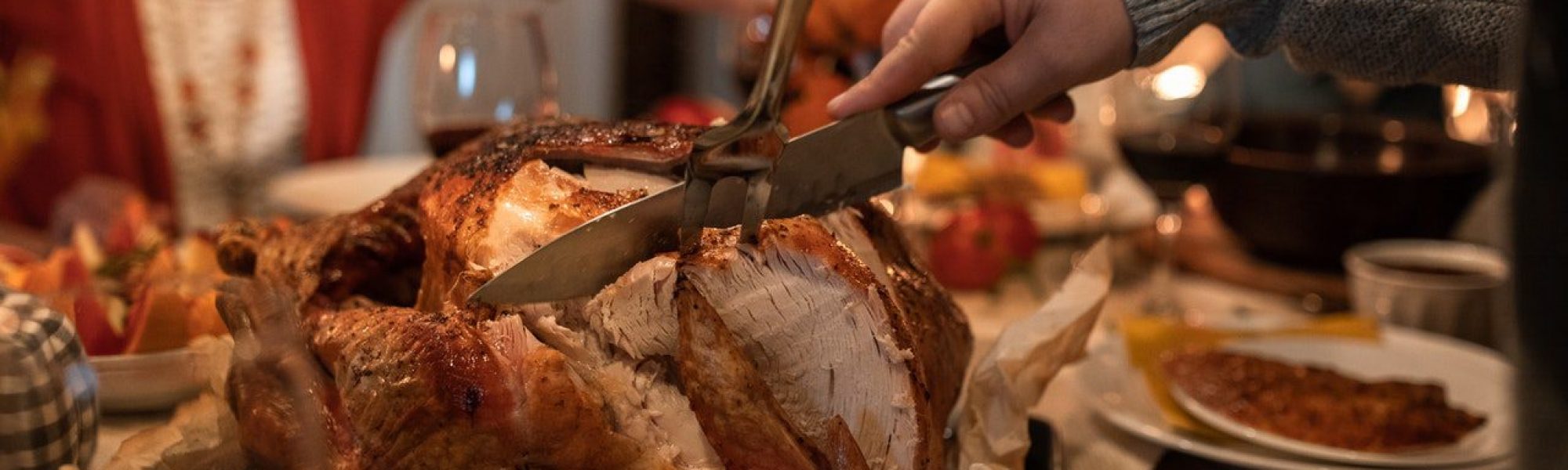 man cutting a turkey at thanksgiving